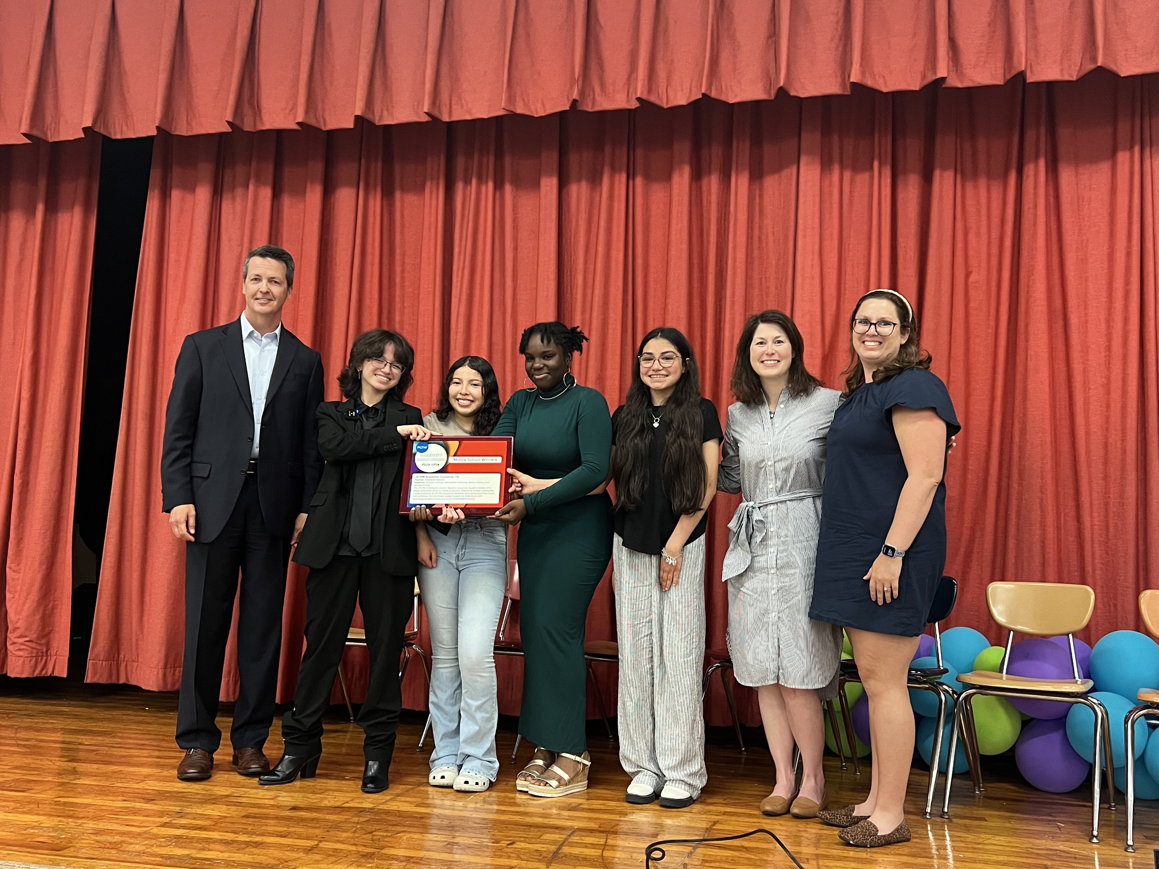 students and their teacher pose with PLTW leaders